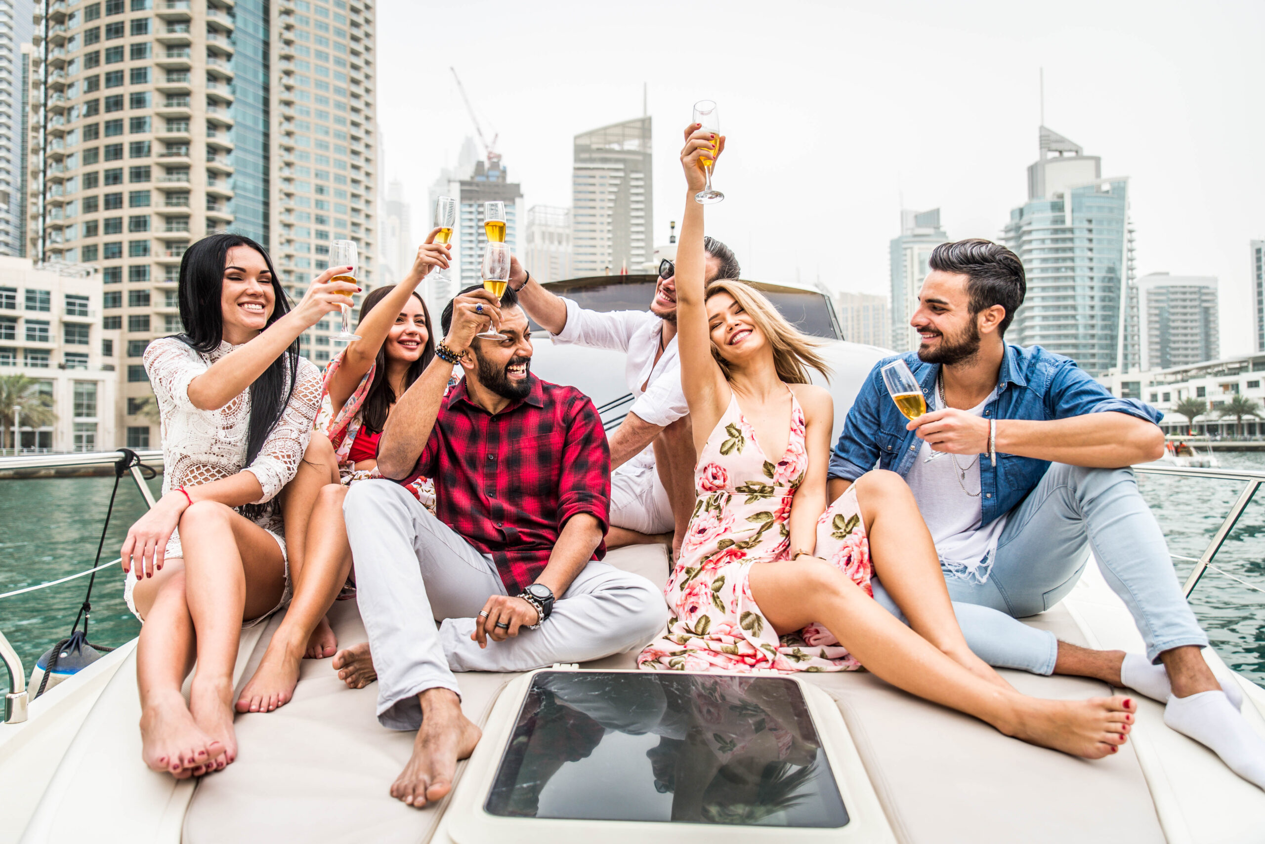 Group celebrating with drinks on a luxury yacht, symbolizing high-end investment opportunities.