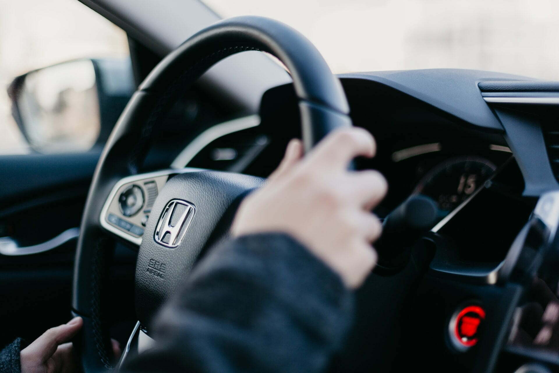 a hand holding a steering wheel