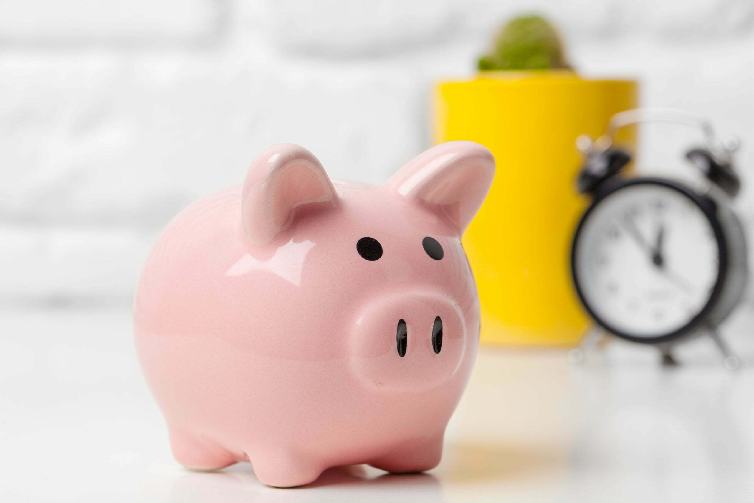 a pink piggy bank with a yellow cup and a green cup
