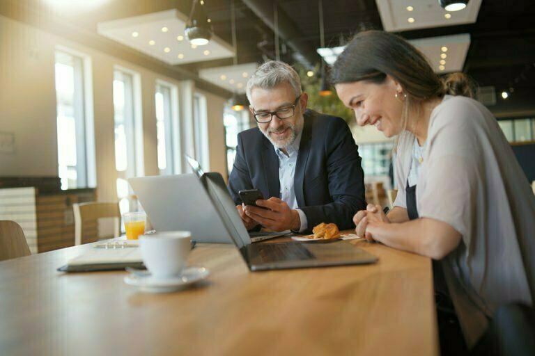 a man and a woman looking at a laptop