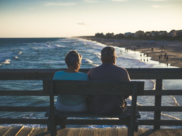 a couple sitting on a bench overlooking a body of water