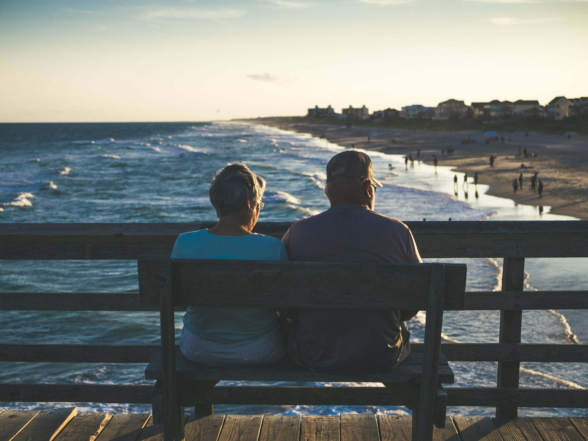 a couple sitting on a bench overlooking a body of water