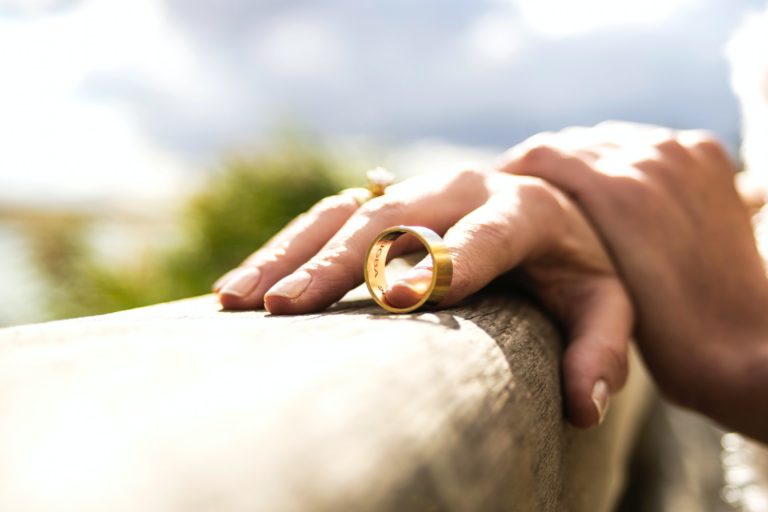 a person holding a small gold ring
