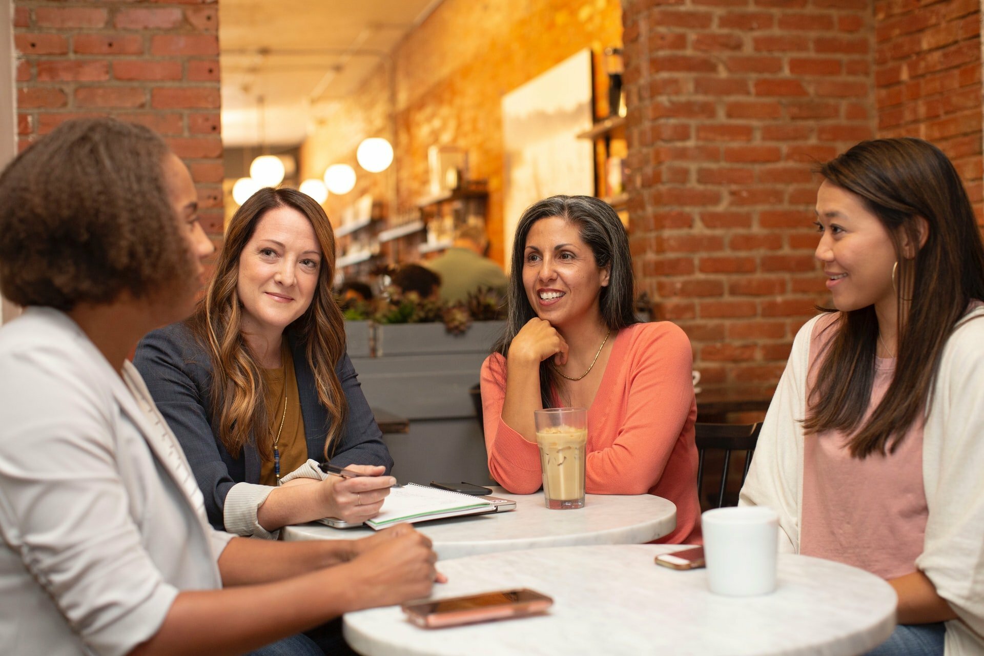 a group of women sitting at a table smiling