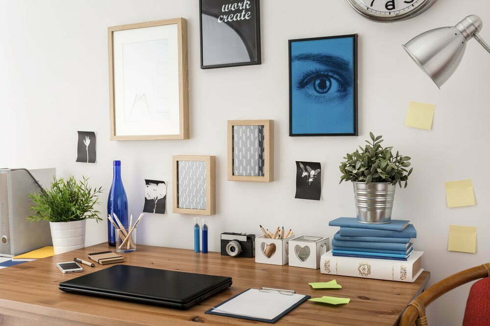 a desk with a laptop and pictures on it