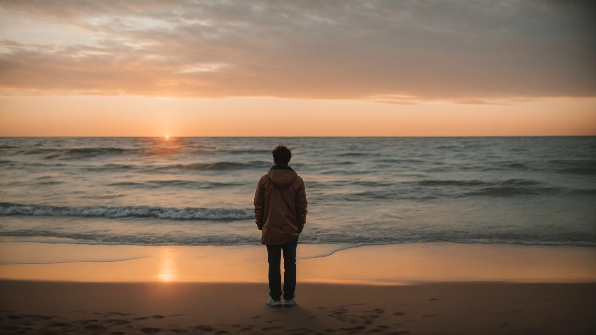 a lonely person watching the sunset from a quiet beach, signifying a moment of reflection and moving forward.