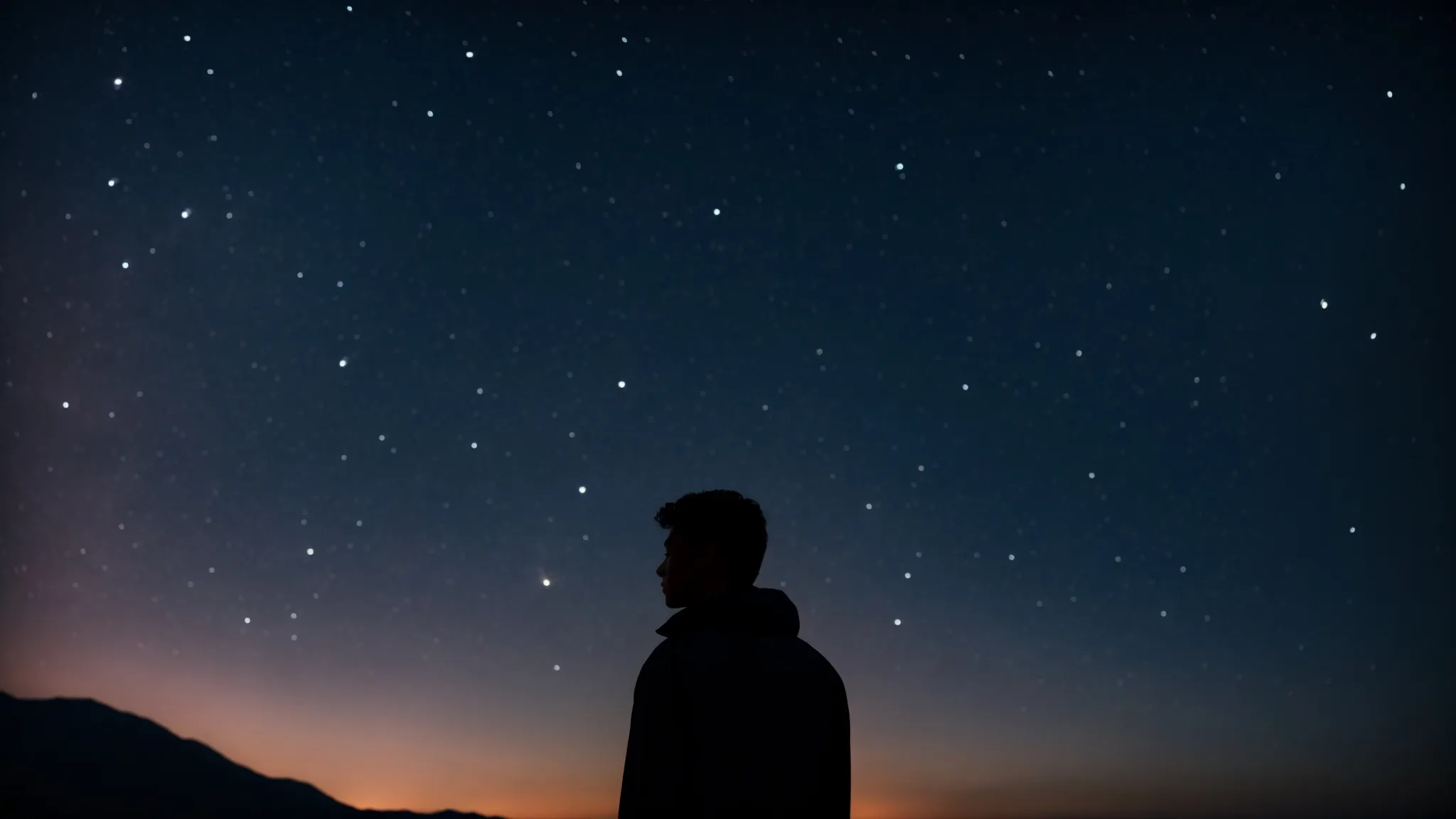 a person gazes towards the night sky dotted with stars and the silhouettes of zodiac signs.